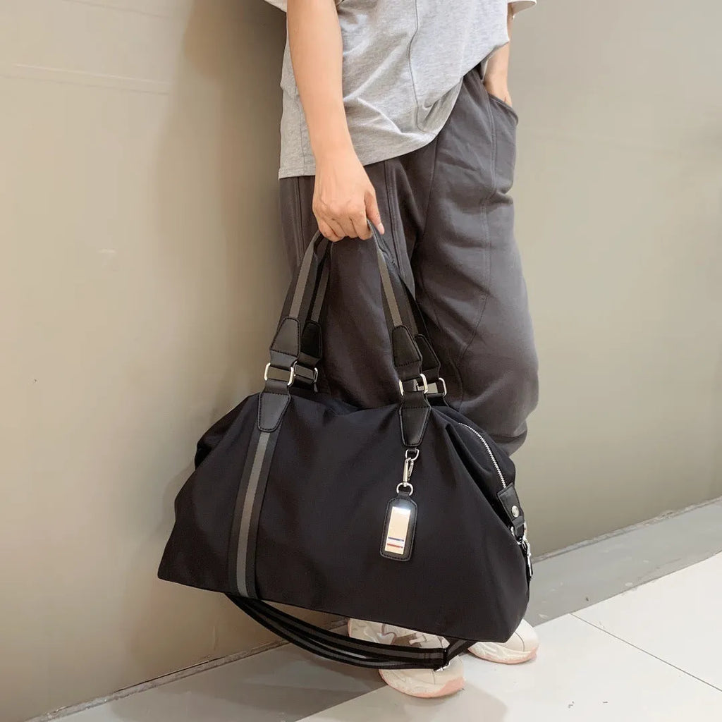 Black Gold Oxford cloth travel bag with zipper closure and three shoulder strap points on plain background