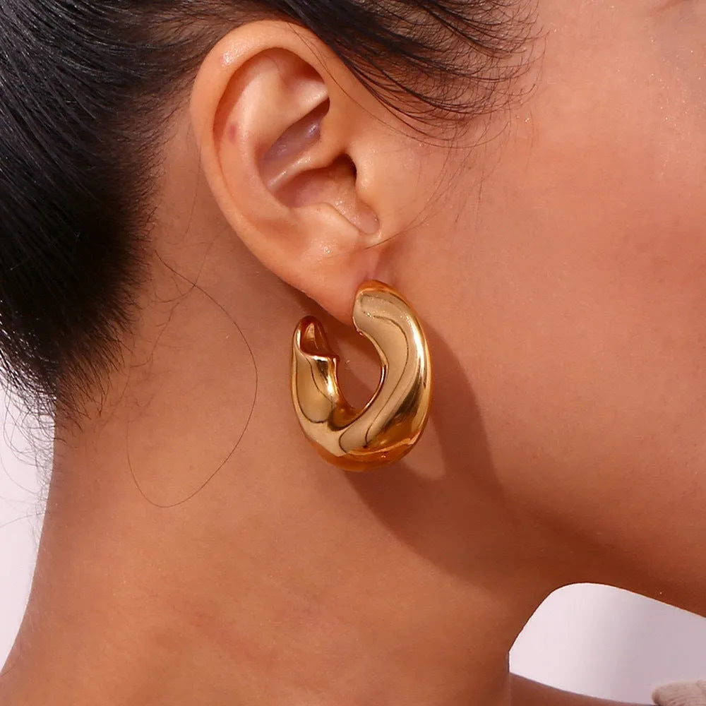 Gold and silver hollow irregular stainless steel earrings with geometric line design on white background