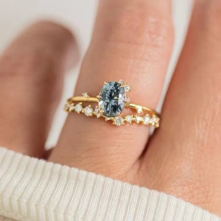 Gold plated floral women's ring with inlaid green zircon stones on a white background.