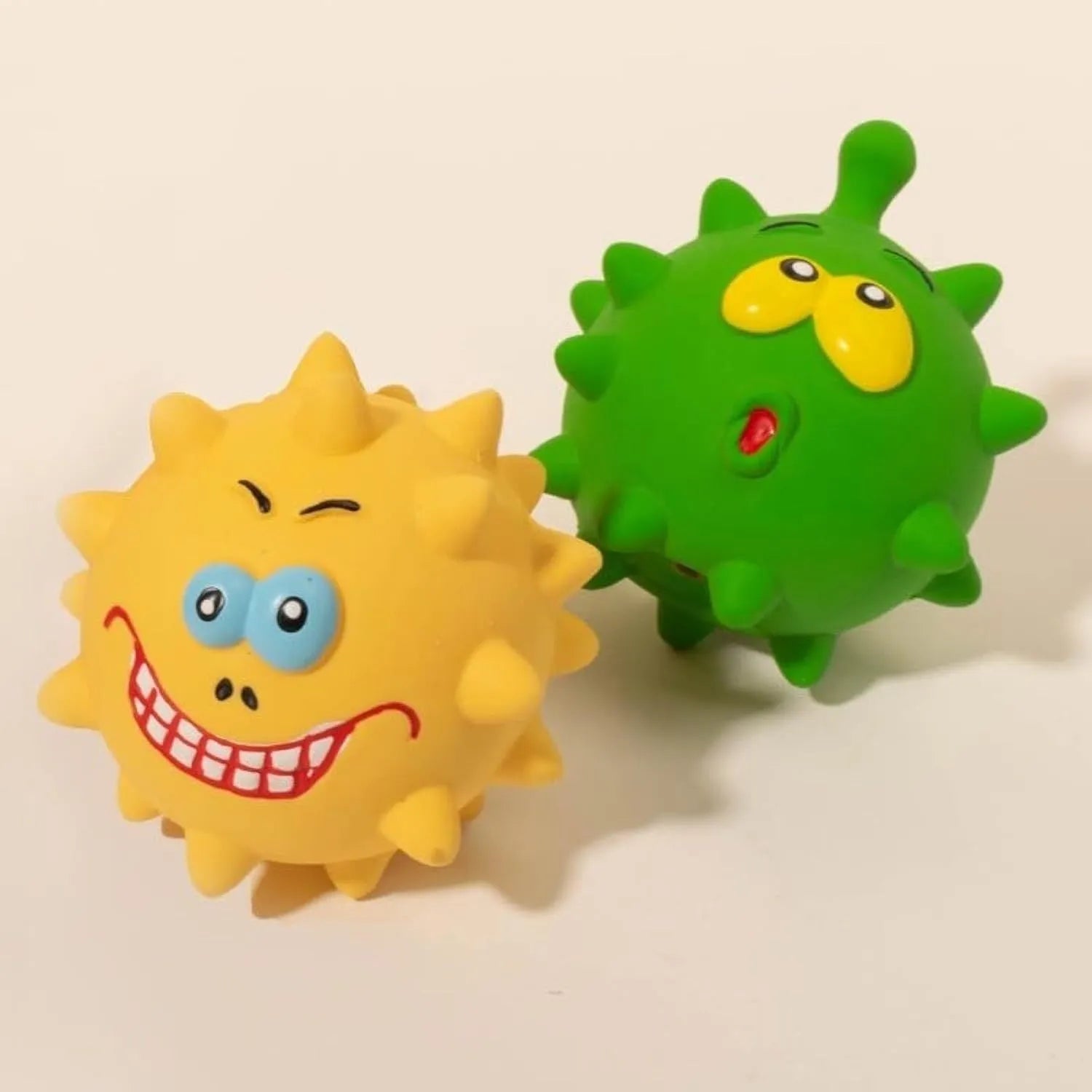Four natural latex rubber dog squeaky balls with cute faces in blue, green, red and yellow colours