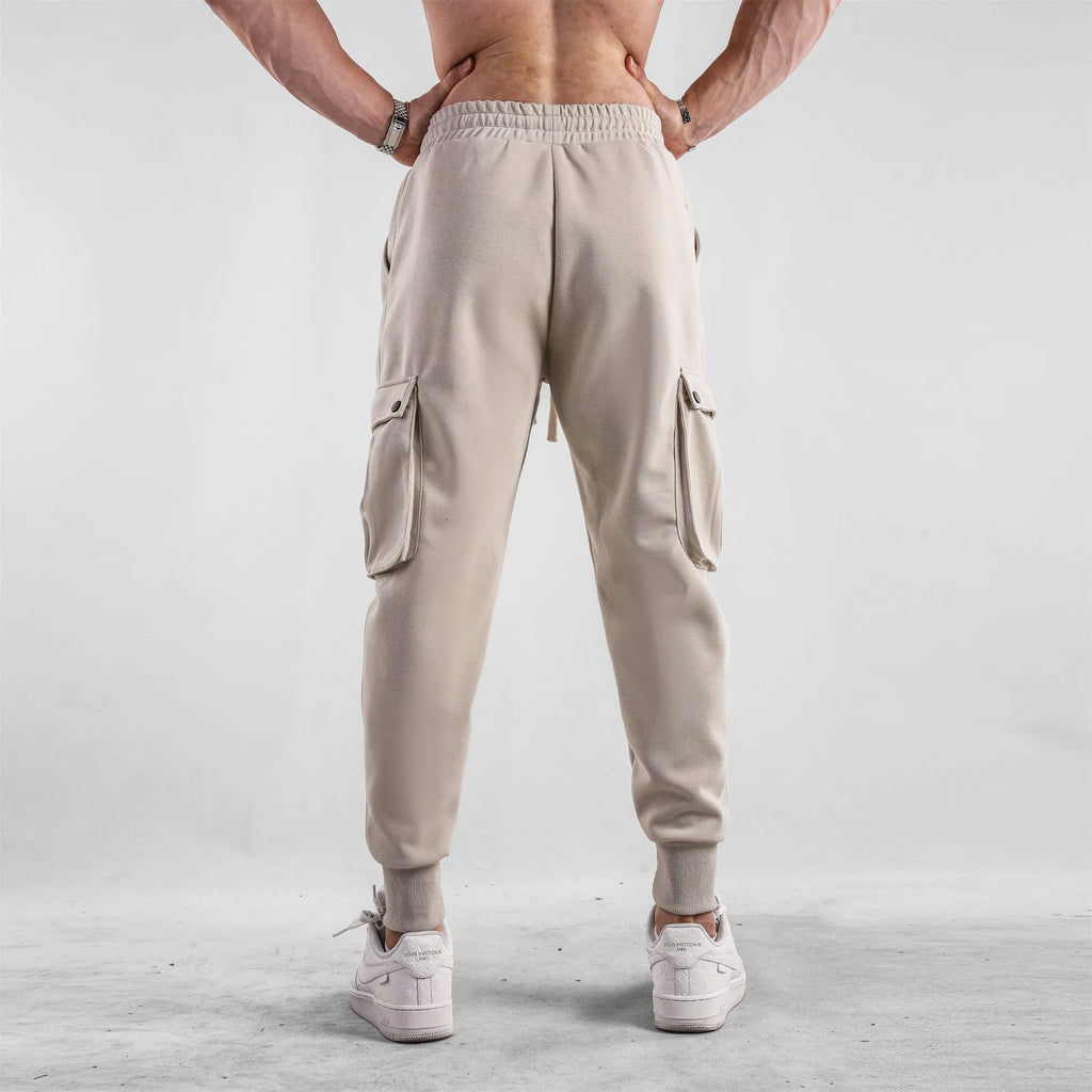 Men's loose fit cotton sports trousers with ankle ties in apricot colour showing multiple pockets