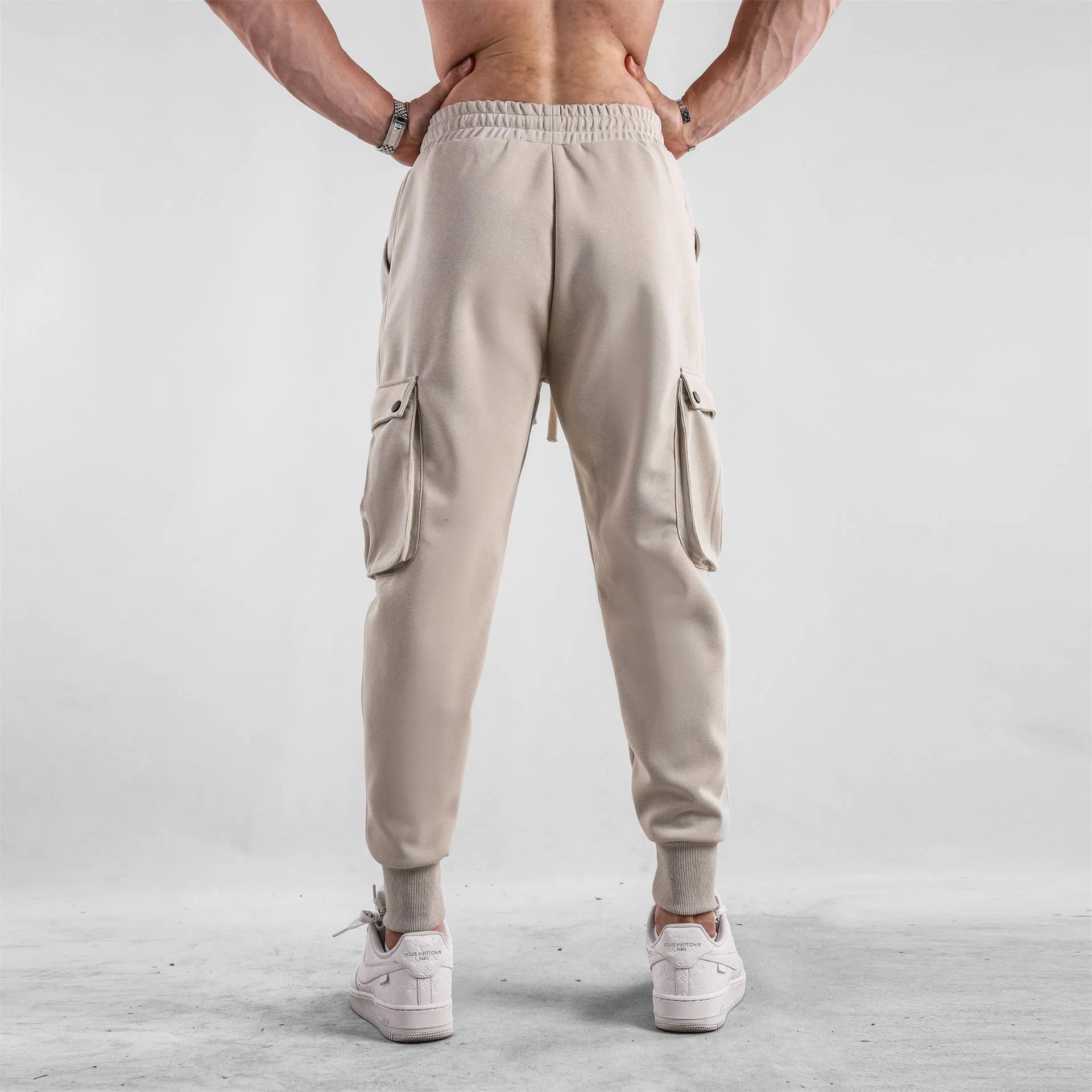 Men's loose fit cotton sports trousers with ankle ties in apricot colour showing multiple pockets