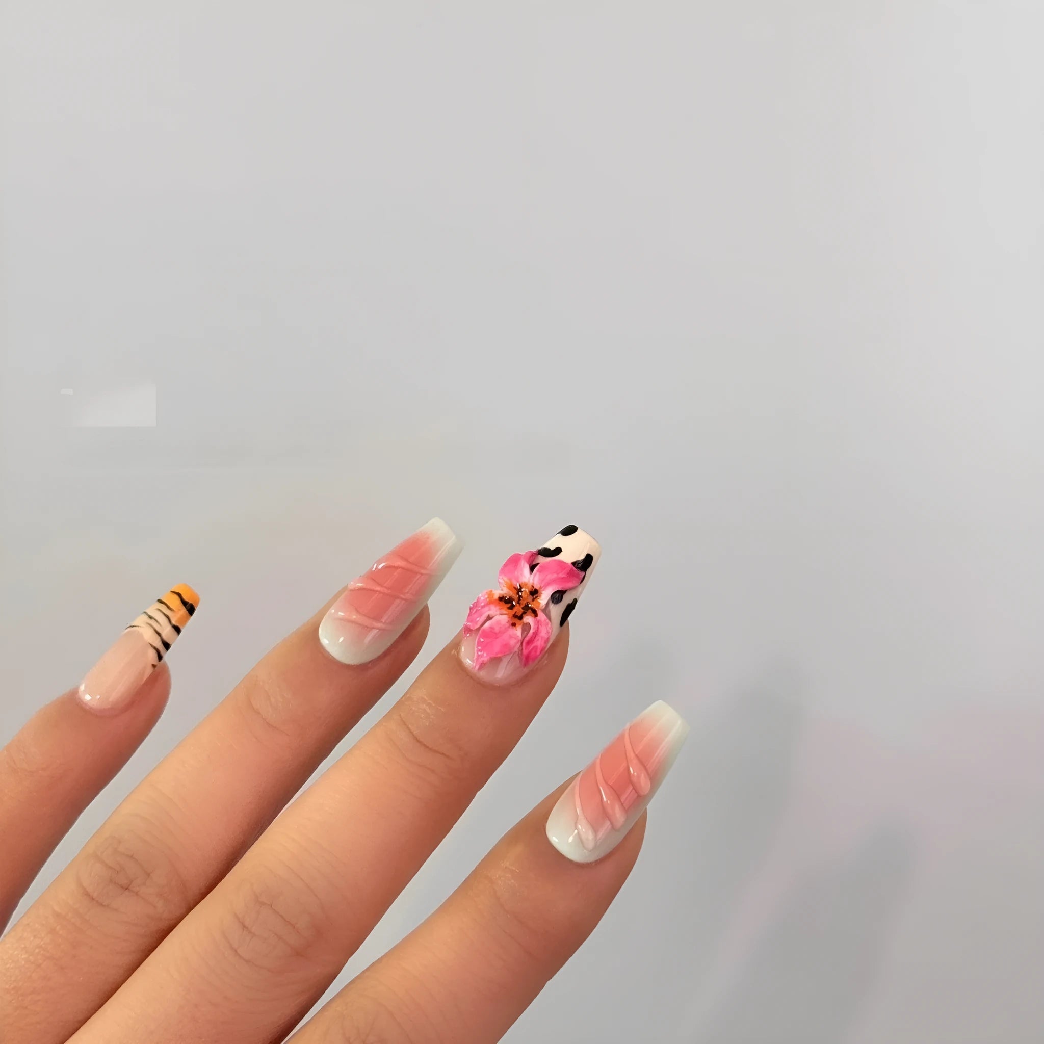 Hand-carved artificial nails with raised zebra pattern and floral designs, shown in long style.