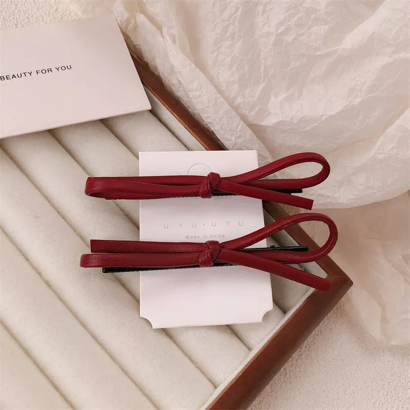 Wine red leather bow barrette hair clip for women showing manual crafted detail
