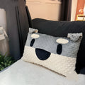 Grey and white West Highland terrier puppy-shaped dog pillow on a sofa.