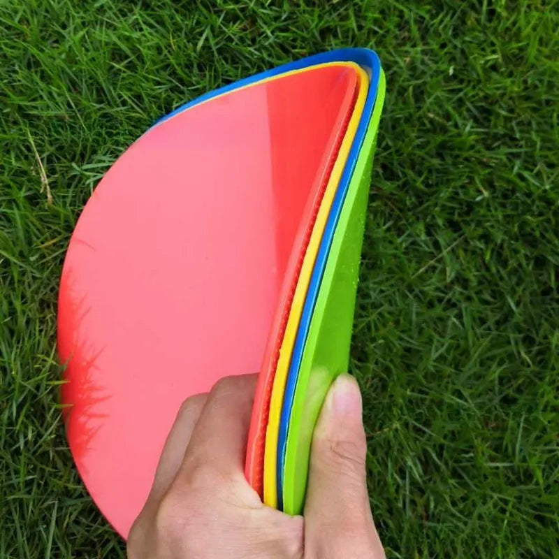 Yellow football training target disc with 23cm diameter on grass pitch