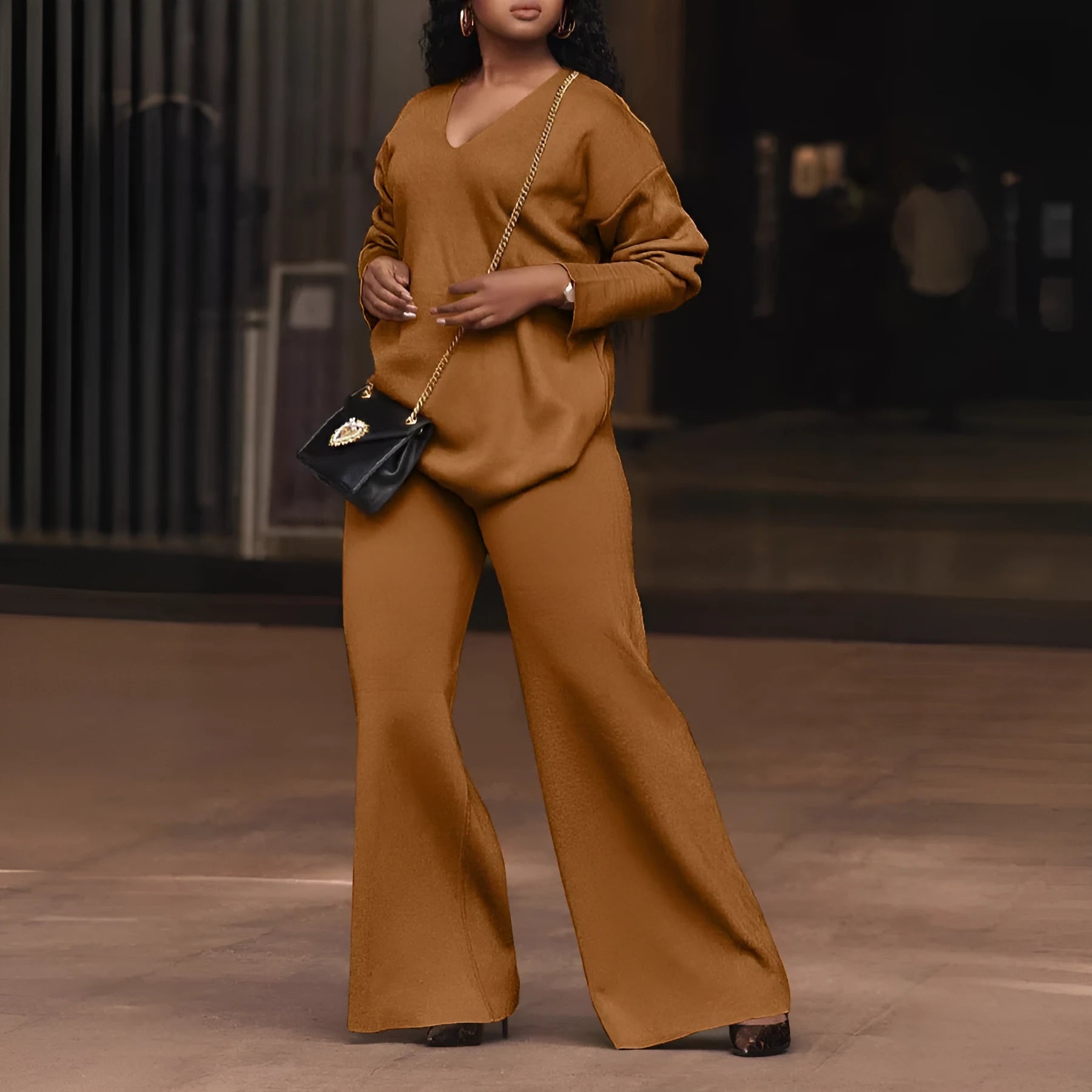 Women's brown thickened suede two-piece suit with split sleeve top and trousers on a hanger.