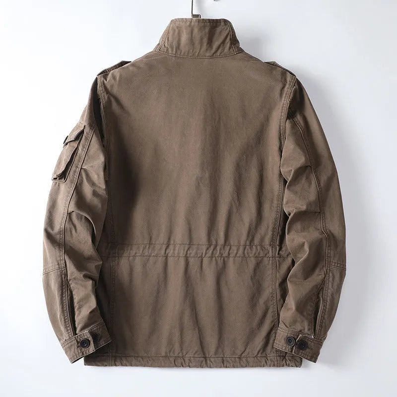 Man wearing a loose-fit light brown cotton twill zip-up jacket with a retro style.