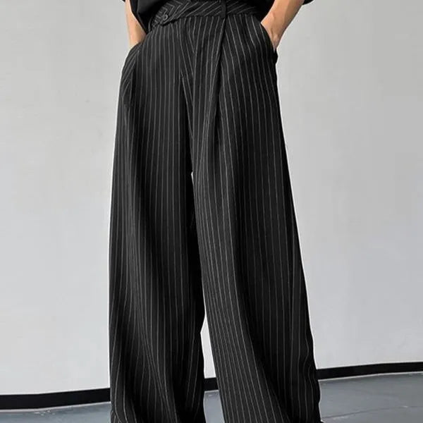Man wearing black vertical striped pleated casual trousers with an elasticated waistband.