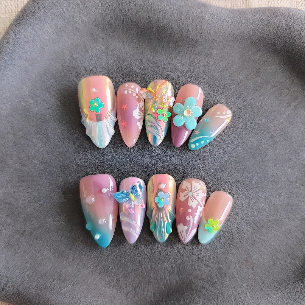 Handmade colourful false nails with 3D embossed flowers and butterflies on almond-shaped nails