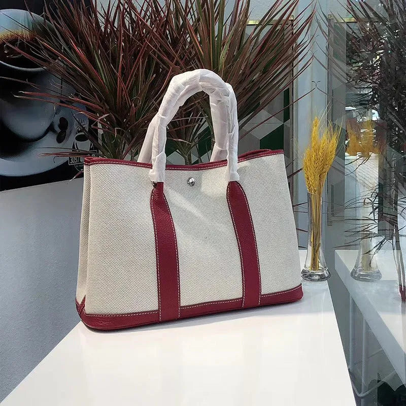 Women's genuine leather crossbody tote bag with canvas trim in bucket shape showing internal document and zipper compartments