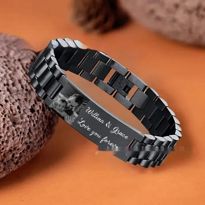 Titanium steel men's bracelet with curved heart shape design and black lettering on grey background