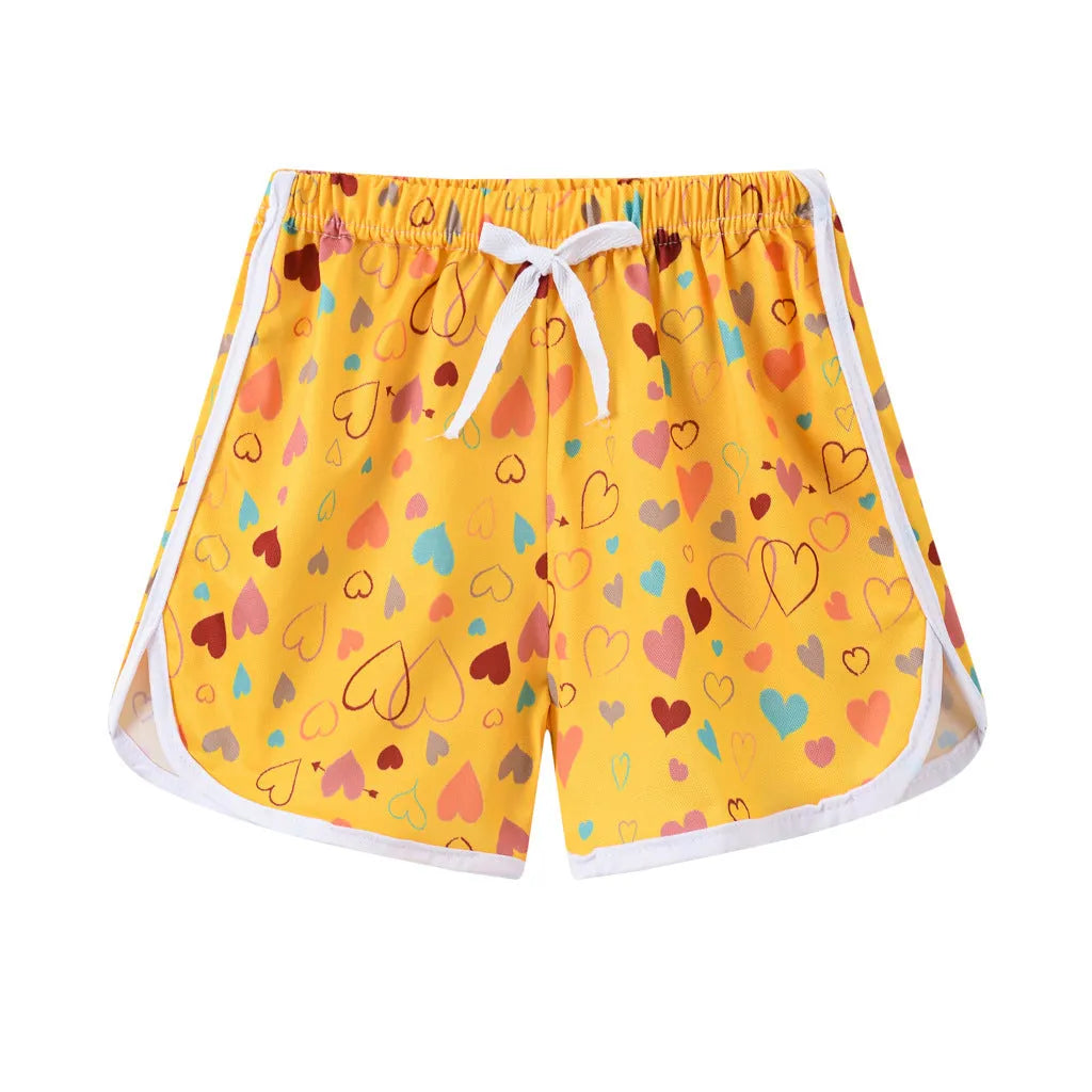 Children's polyester holiday shorts in multiple colours and patterns including stripes, leopard print, and pineapple design.