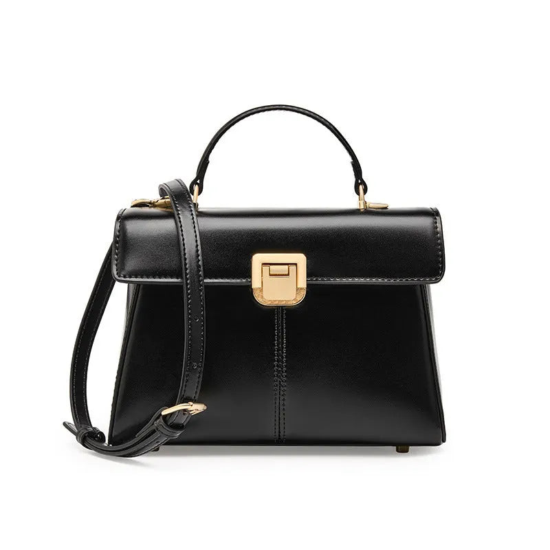Women's black leather shoulder bag with clasp closure and adjustable strap showing interior organisation