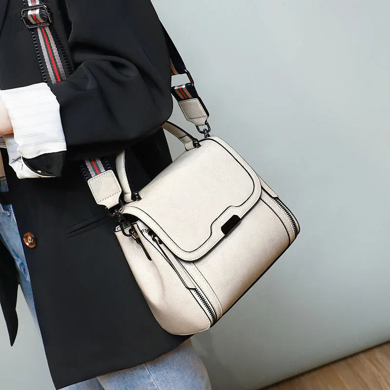 Women's brown genuine leather retro messenger bag with double strap and external pockets.