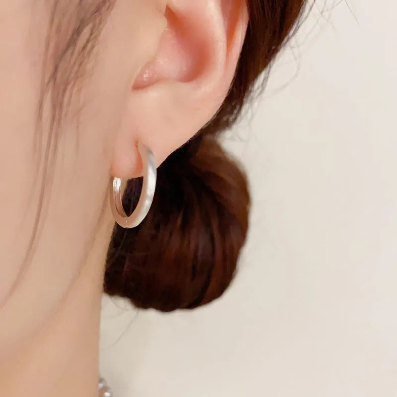 A pair of geometric circle ear clips for women in gold or silver finish.