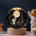 Luminous crystal ball on a wooden base projecting a starry sky pattern, USB cable connected.