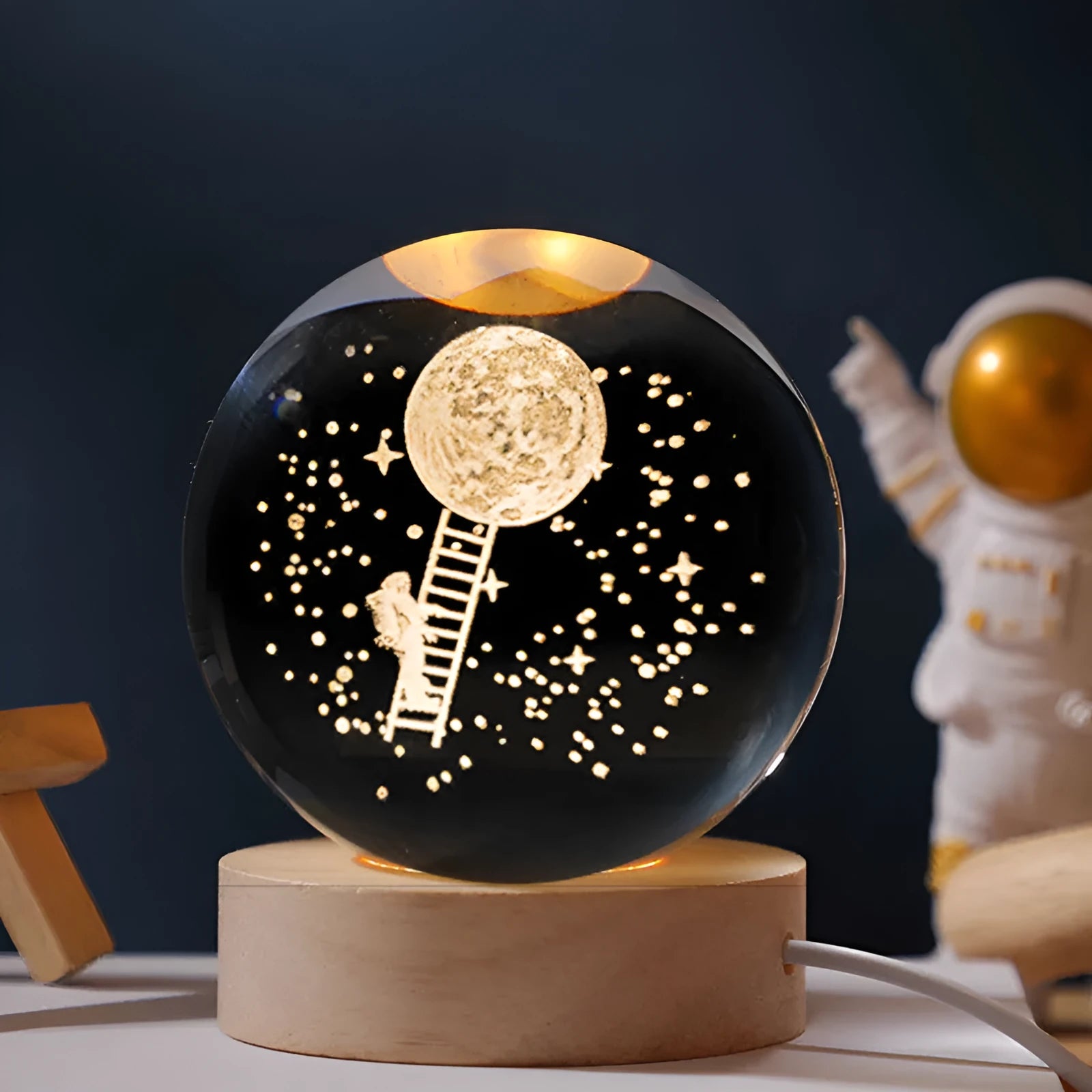 Luminous crystal ball on a wooden base projecting a starry sky pattern, USB cable connected.
