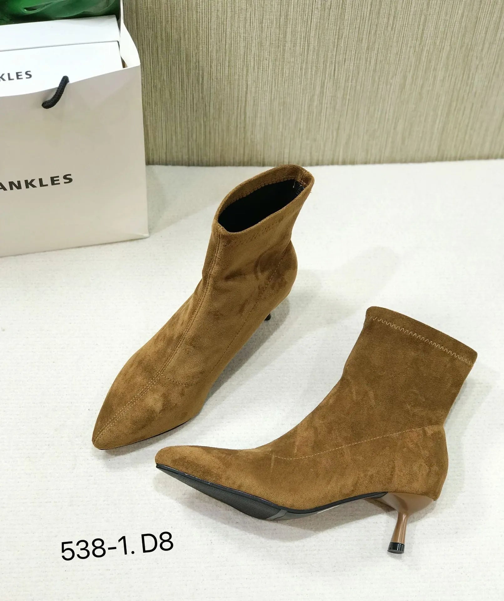 Women's black pointed-toe ankle boots with a stiletto heel and mid-calf sock length.