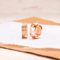 Rose gold coloured earrings with three hollow heart shapes arranged in circular pattern