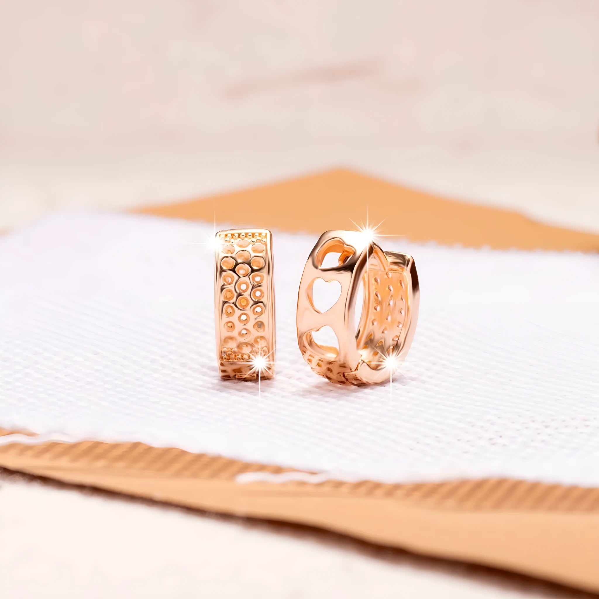 Rose gold coloured earrings with three hollow heart shapes arranged in circular pattern