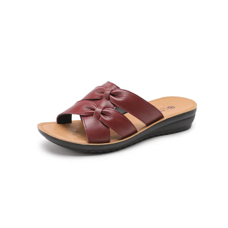 Women's beige cowhide leather slippers with a non-slip sole shown on a white background.
