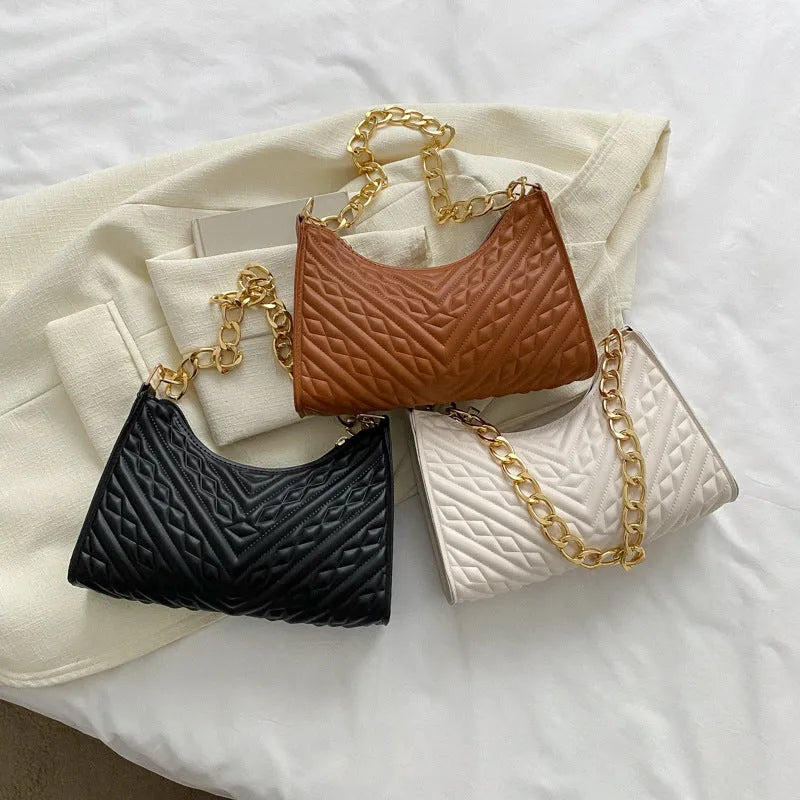 Brown pleated chain shoulder bag with soft handle and adjustable strap showing sewing line detailing
