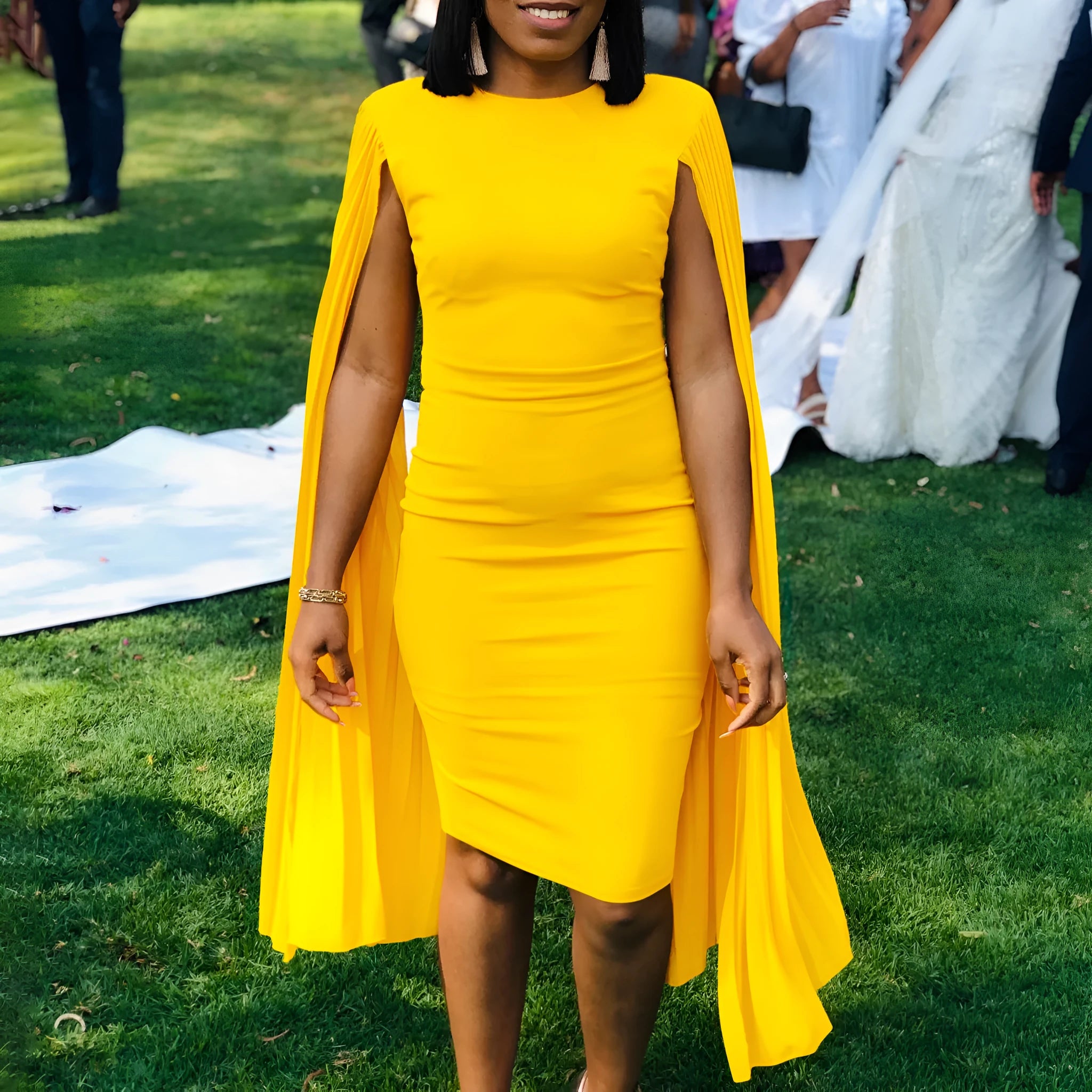 Yellow formal evening dress with long sleeves, a high waist, and an attached pleated shawl.