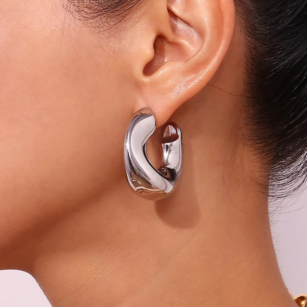 Gold and silver hollow irregular stainless steel earrings with geometric line design on white background