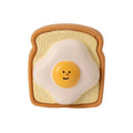 Yellow latex dog chew toy shaped like cartoon bread with squeaker inside
