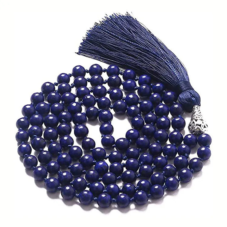 Long beaded agate and amethyst tassel necklace with geometric pendant on a neutral background.