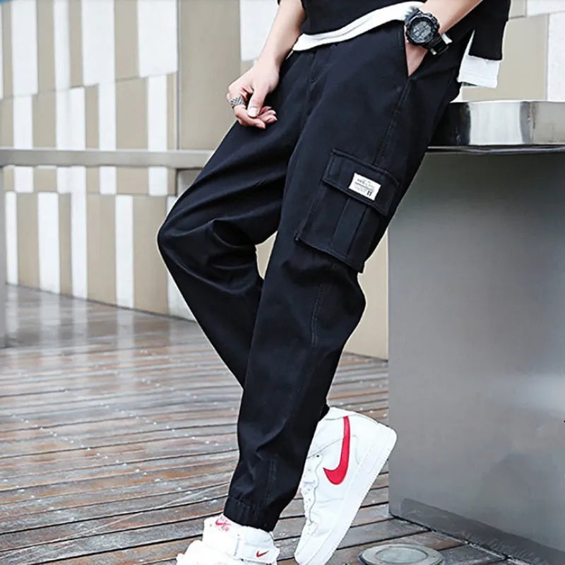 Khaki multi-pocket harem trousers with tapered mid-waist and elastic waistband, polyester fabric