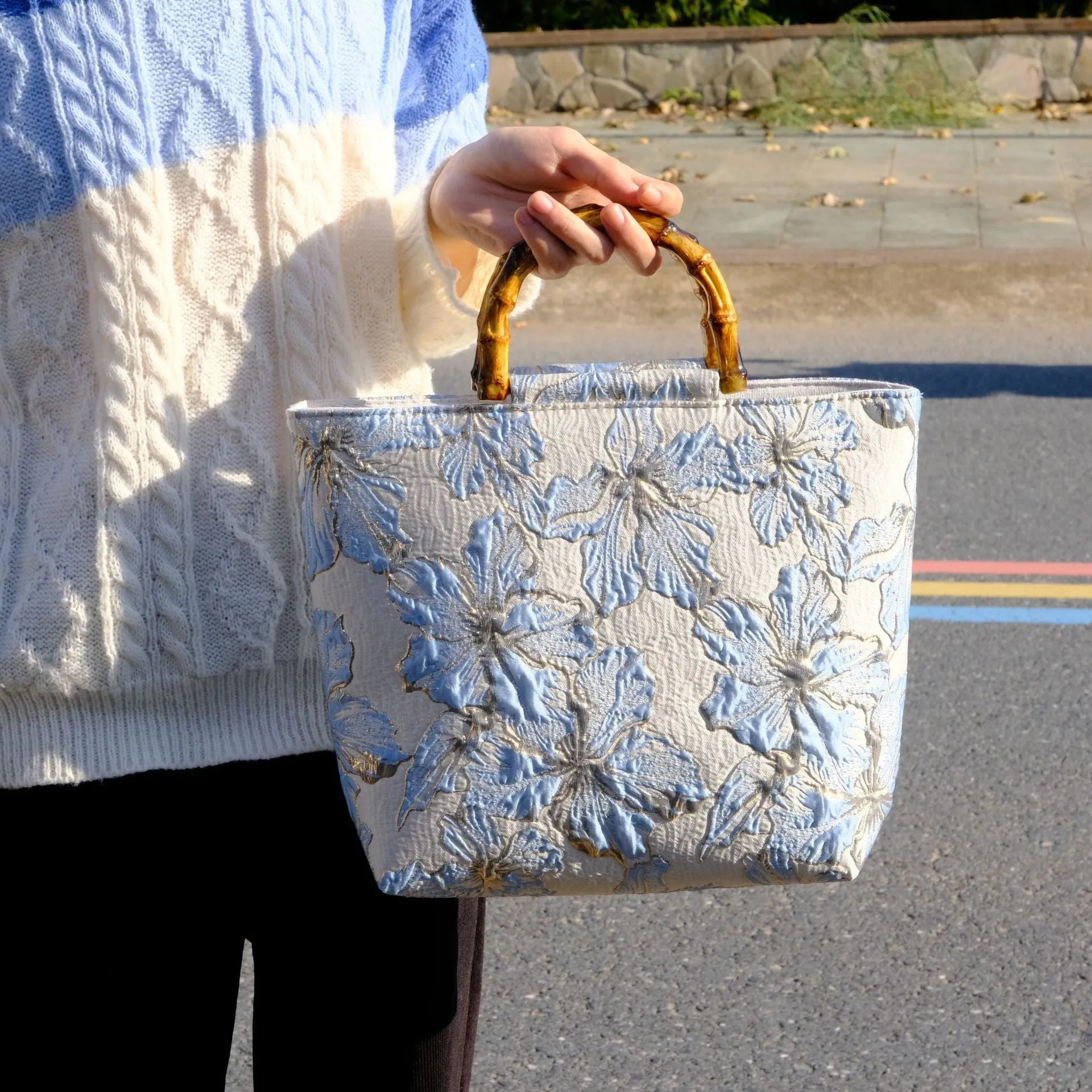 Light blue square canvas shoulder bag with bronzing flower detail and double strap connectors