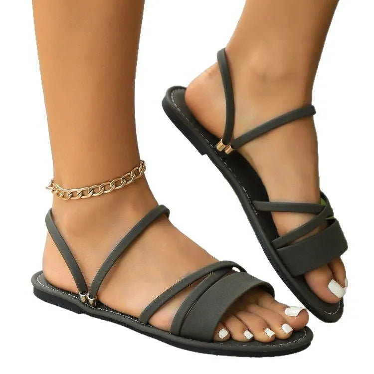 Women's plus size sandals with a flip-toe buckle and cross strap in black.