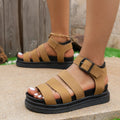 A pair of black casual sandals with a buckle strap and thick rubber sole, showing the fish mouth toe design.