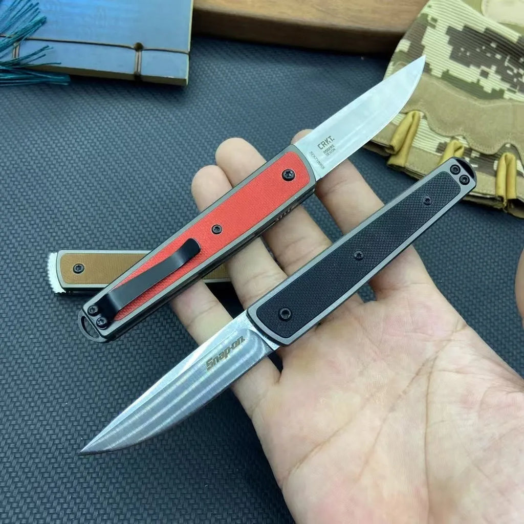 Closed and opened views of a black folding fruit knife showing the stainless steel blade and handle.