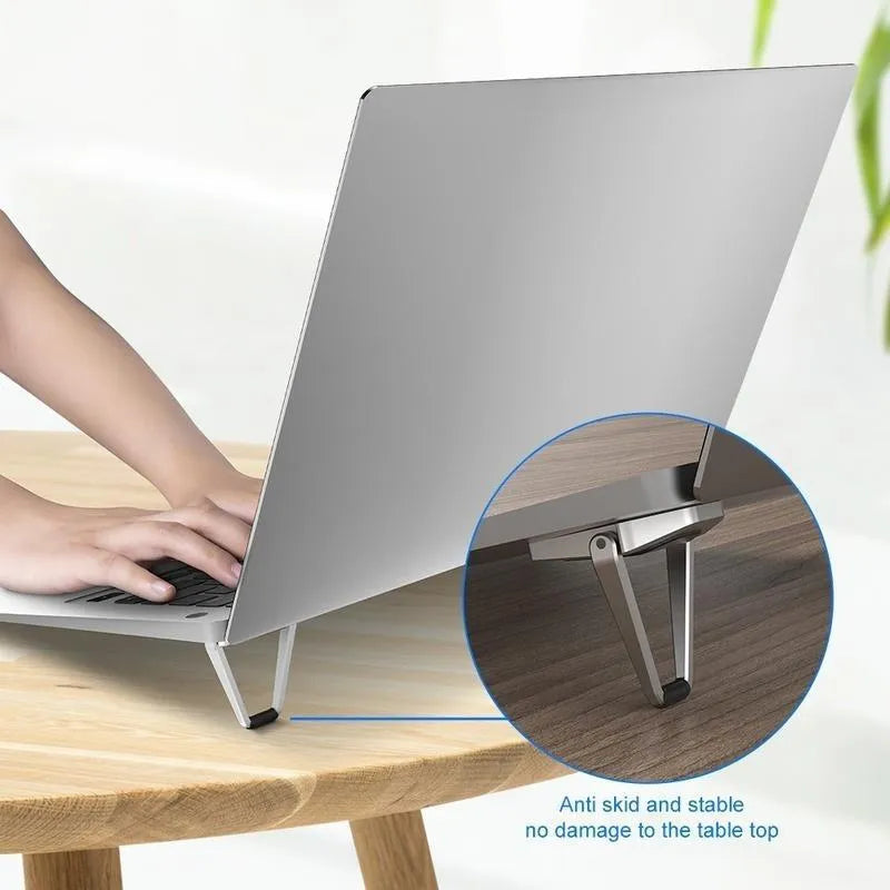 Small foldable aluminium alloy laptop bracket in silver, shown next to 3M adhesive strips for mounting.