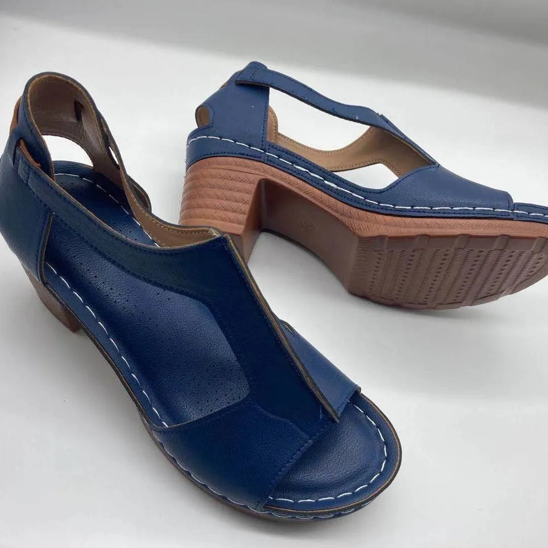 Women's beige peep toe wedge sandals with ankle buckle, shown on a foot.
