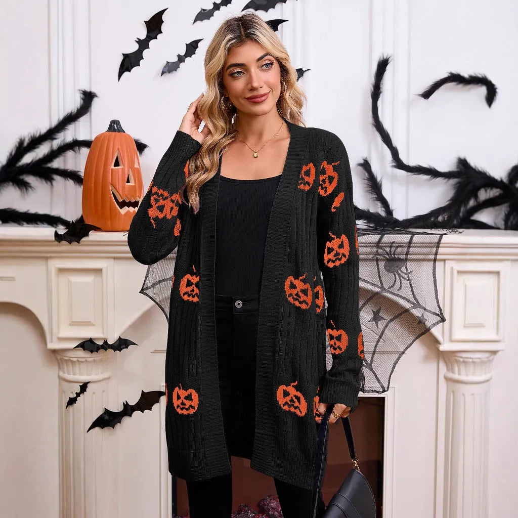 Women's black Halloween cardigan with orange Jacquard knitted pumpkin head pattern, shown on a hanger.