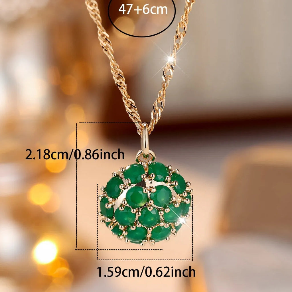 Round emerald pendant necklace with diamond surround on champagne gold chain
