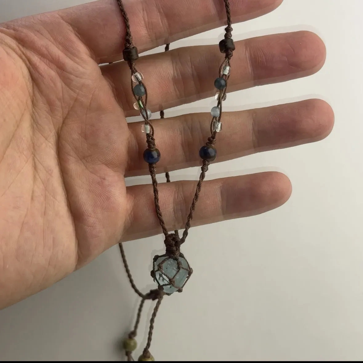 Artificial crystal rough labradorite-style pendant necklace with O-link chain on display