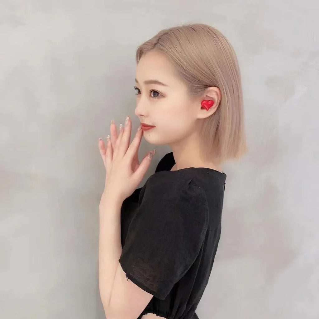 Heart-shaped wireless Bluetooth earphones in red and pink colours with charging cable