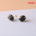 Rough stone crystal earrings with gold plated four claws on a black background