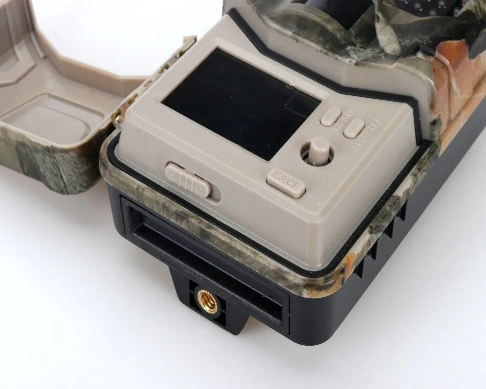 Camouflage trail camera with LCD screen showing a night-time infrared image of a deer.