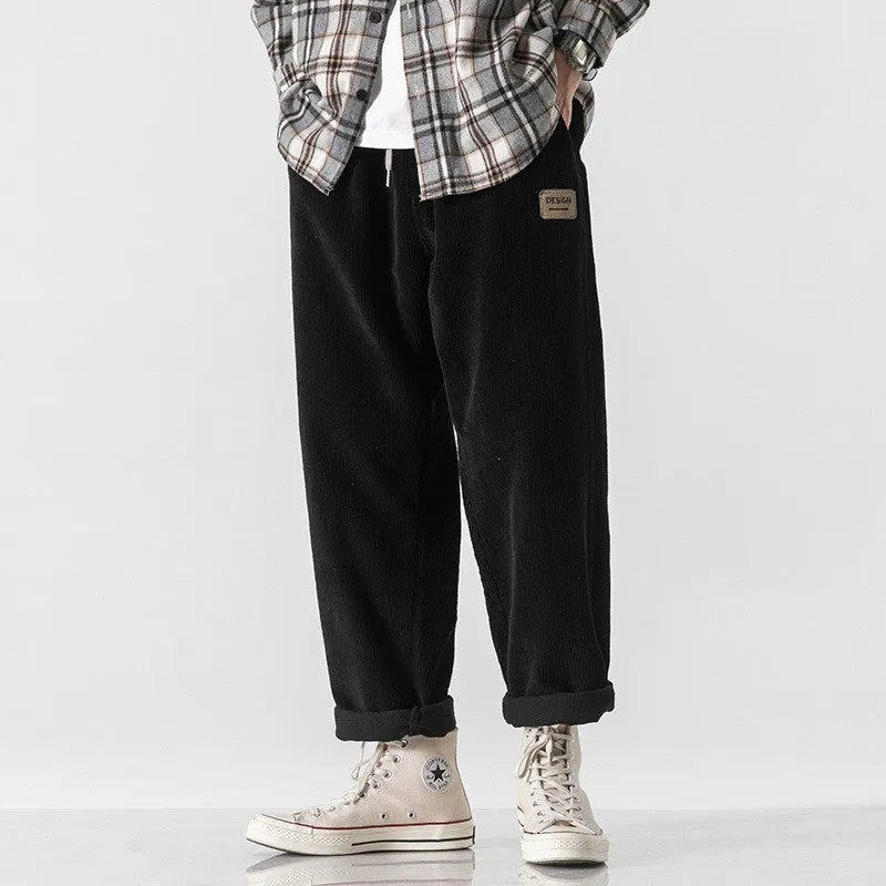 Men's loose straight corduroy sports trousers in army green colour on a hanger