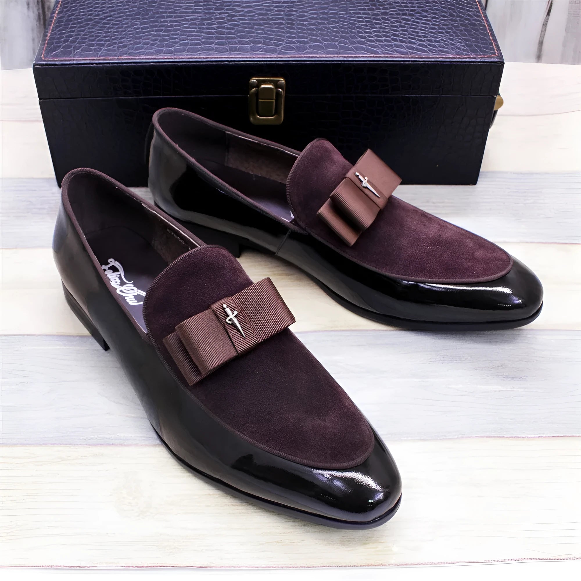 Men's glossy patent leather dress shoes with tassel detail in black, showing low-top design and leather toe holder.