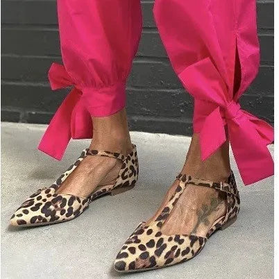 Leopard print women's pointed toe pumps with a cross strap and a low chunky heel.