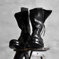 Black Japanese irregular deconstructed leather boots for men with high cylinder, round toe, thick bottom, and zipper closing.