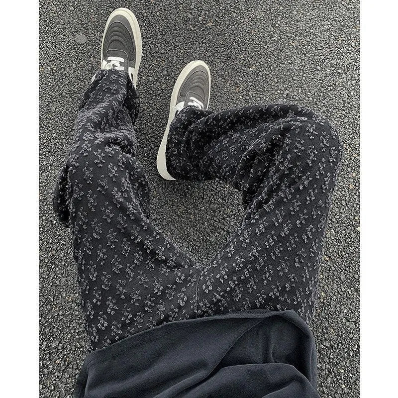 Men's black jacquard full-print denim jeans with button fly, laid flat showing all-over pattern
