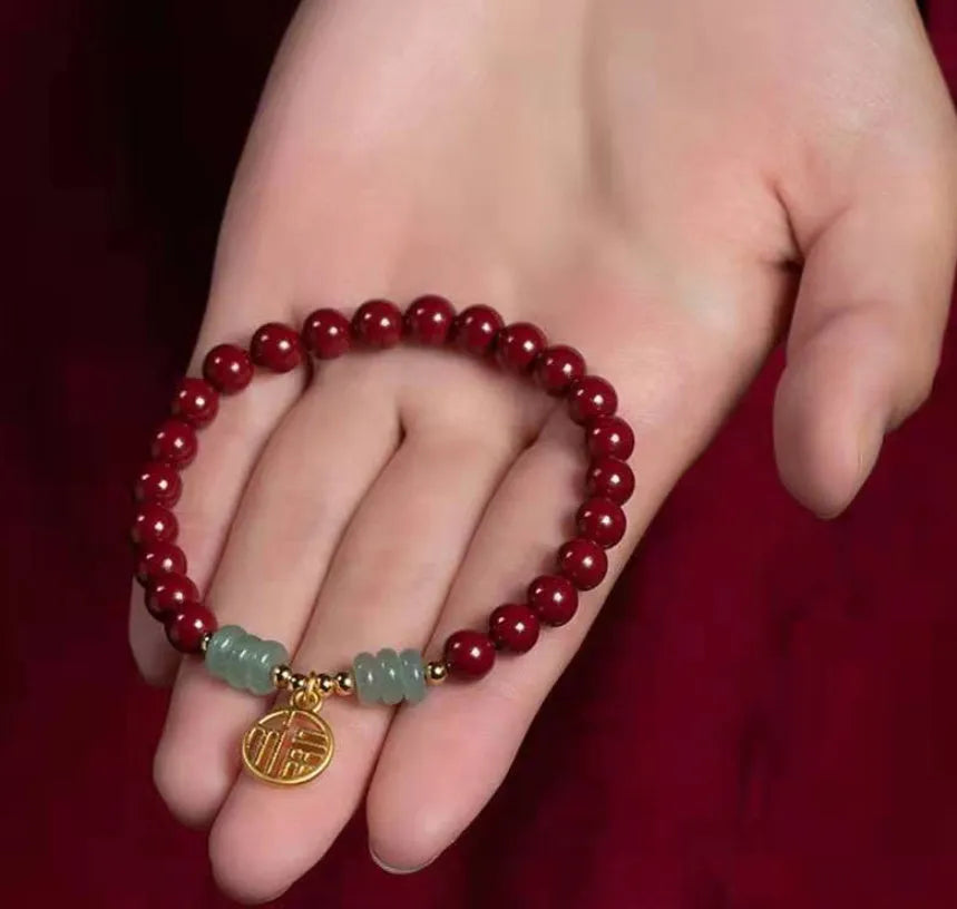 Close-up of a handcrafted wave-pattern bracelet made from red cinnabar and copper beads.